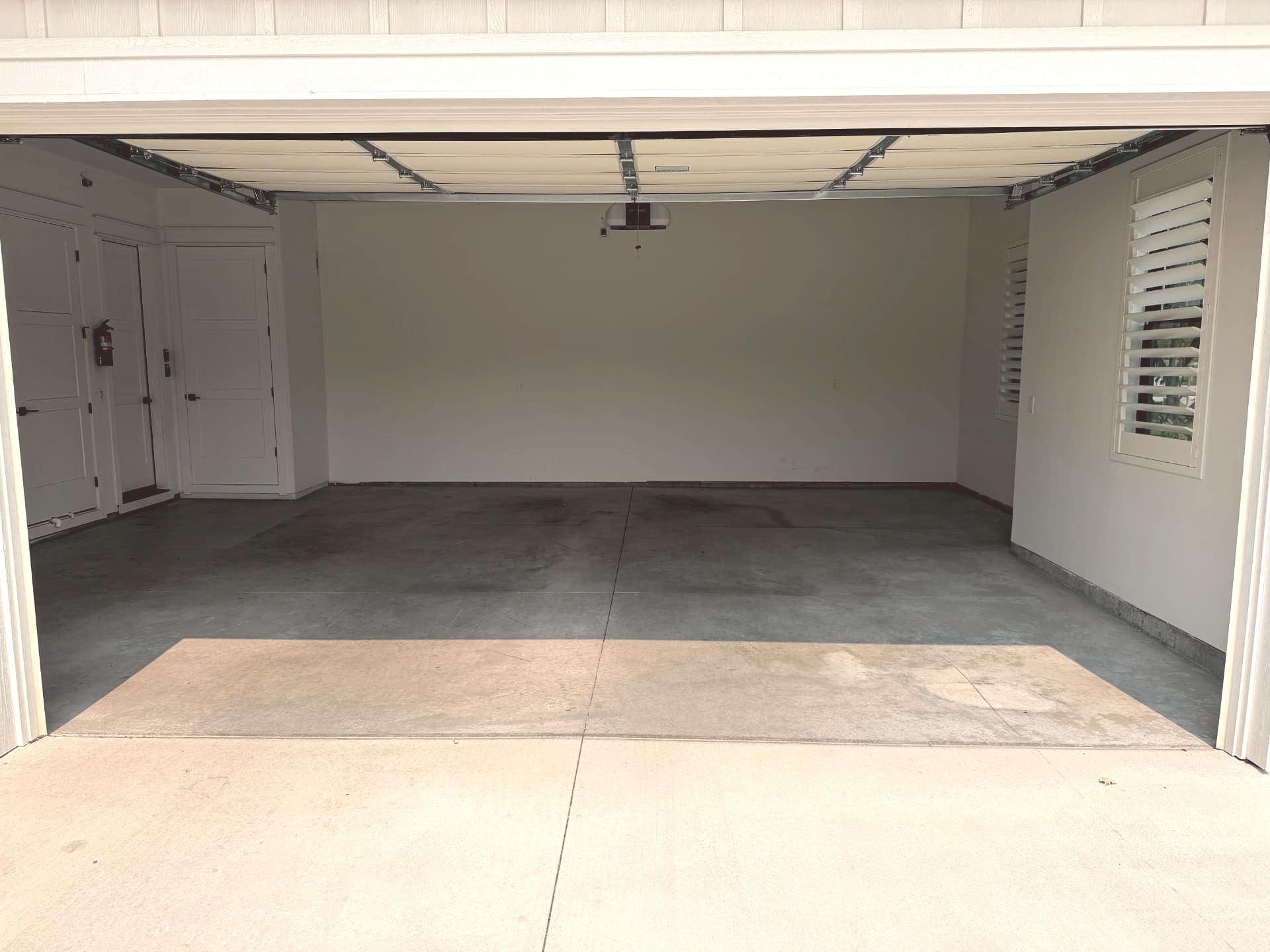 The same residential garage before coating, showing bare stained concrete